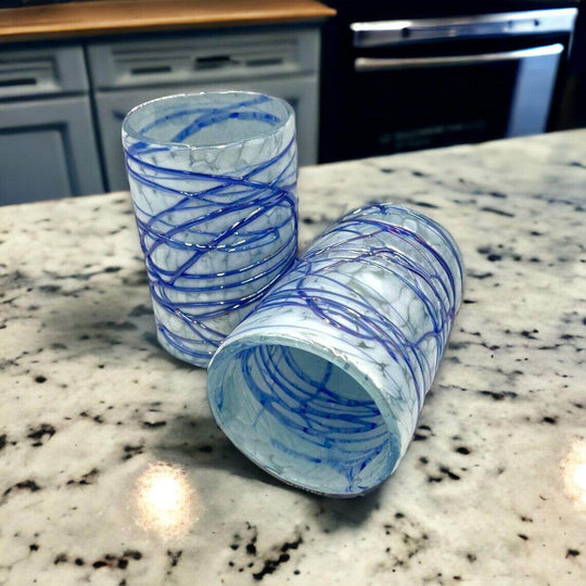 Mexican Hand Blown Drinking Glasses | White and Blue Artisan Glassware - two frosted marbled glasses with swirled cobalt detailing on marble countertop