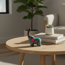 Colorful ceramic Alebrije elephant figurine shown on a round table