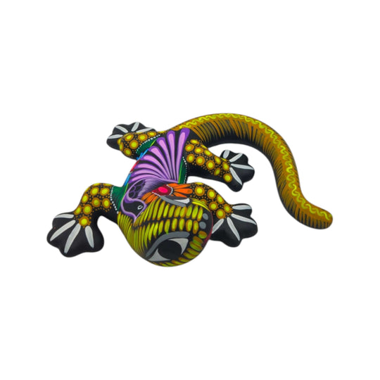 Side view of a colorful ceramic Alebrije lizard figurine showing its curled tail