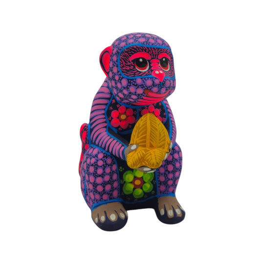 Front view of a multicolor ceramic Alebrije monkey figurine holding a butterfly