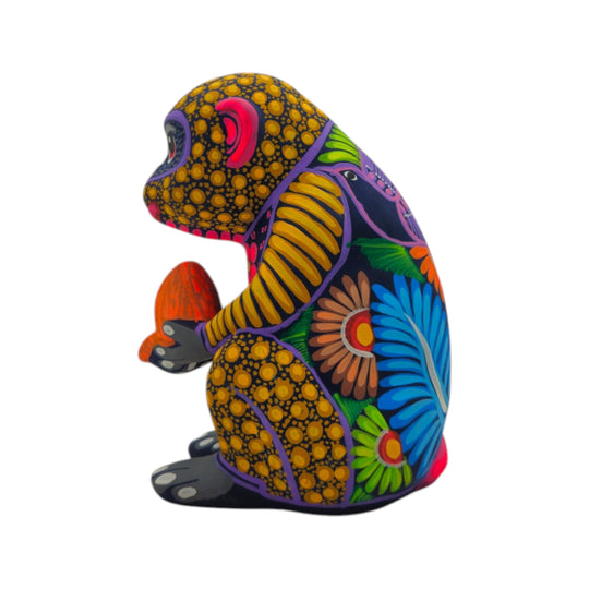 Side view of a multicolor ceramic Alebrije monkey figurine with floral patterns