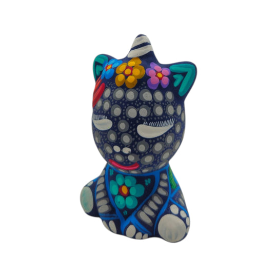 Back view of a blue Alebrije unicorn figurine with white dotted patterns