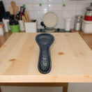 Black on Black Talavera Spoon Rest | Mexican Handcrafted - glossy black ceramic spoon rest with intricate floral motifs on wooden kitchen counter