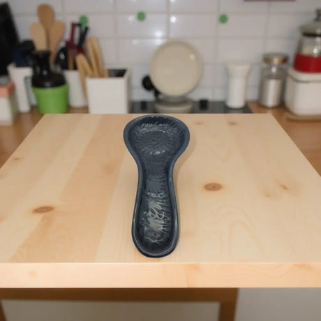 Black on Black Talavera Spoon Rest | Mexican Handcrafted - glossy black ceramic spoon rest with intricate floral motifs on wooden kitchen counter