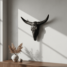 Matte black Talavera longhorn wall art above a wooden console in a bright room