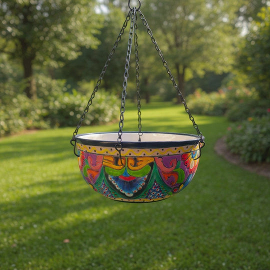 The Talavera Hub hand-painted ceramic hanging planter with blue rim, floral motifs, and drainage hole.