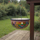 The Talavera Hub hand-painted ceramic hanging planter with blue rim, floral and geometric motifs. Includes chain and drainage hole.