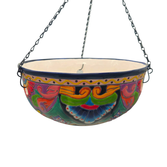 The Talavera Hub hand-painted ceramic hanging planter with blue rim, floral and geometric motifs, and a drainage hole.