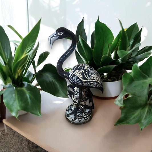 Blue & White Talavera Flamingo Statue | Hand-Painted Bird Pottery displayed among green houseplants on a shelf, handcrafted kiln-fired piece
