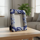 Angled view of a blue and white Talavera picture frame standing on a table