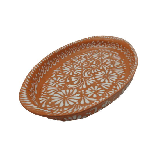 Angled view of a brown and white Talavera oval platter with floral border decoration