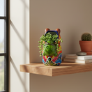 Back view of a colorful capybara Talavera planter on a wall shelf