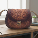 Cincelada Floral Leather Crossbody | Hand Tooled Saddle Purse on table