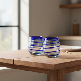 The Talavera Hub hand-blown stemless wine glasses with cobalt blue spiral design. Clear recycled glass, 12 oz capacity.