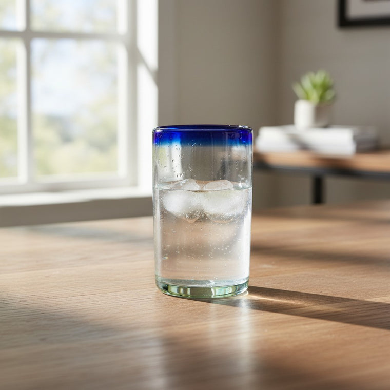 The Talavera Hub hand-blown clear glass tumbler with a cobalt blue rim, 5" tall, perfect for everyday use.