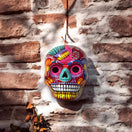 Colorful Calavera Skull | Hand-Painted Mexican Wall Art Decor hanging on brick wall, vibrant hand-painted floral details