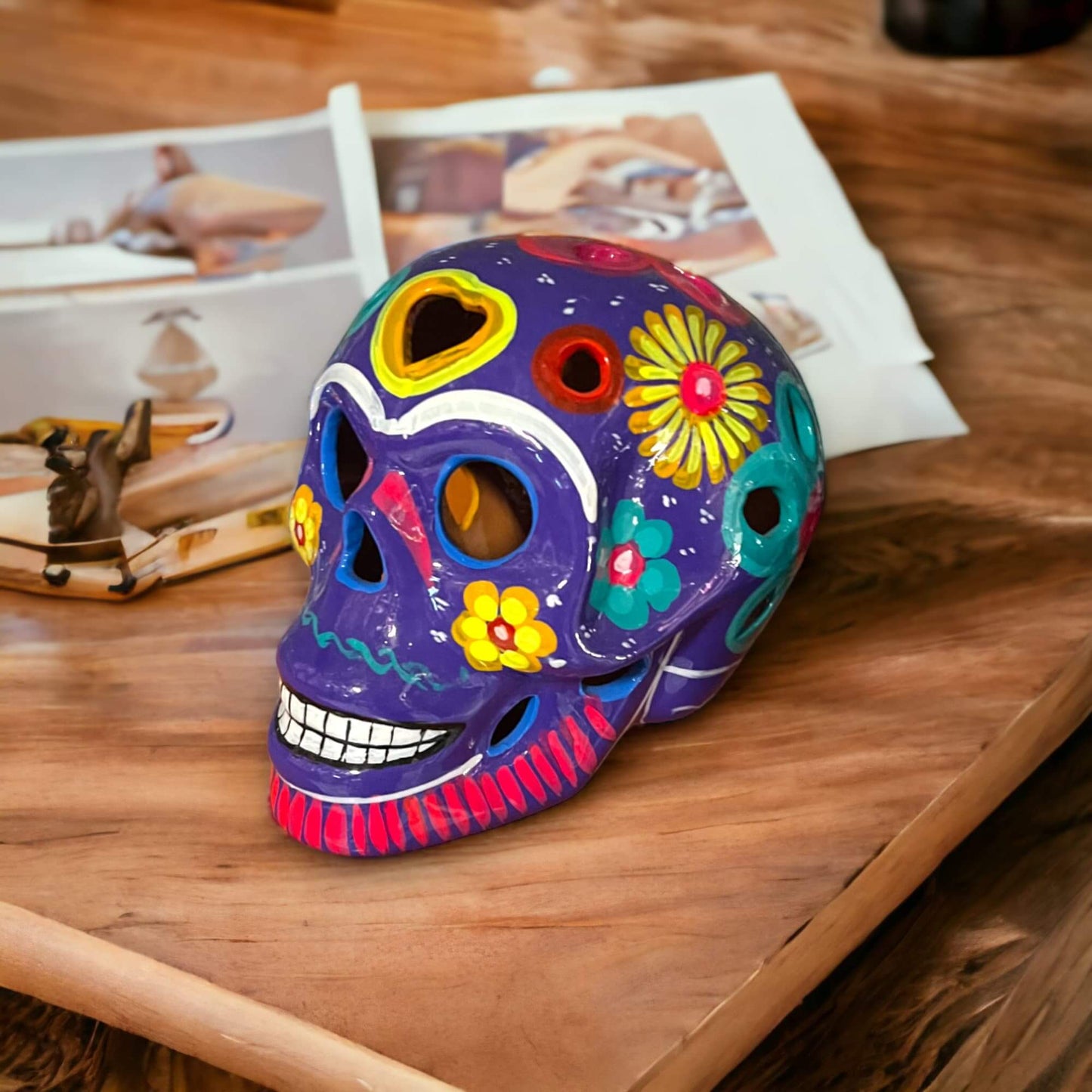 Guerrero Calavera Skull | Large Hand-Painted Day of the Dead Art - vibrant hand-painted purple ceramic skull with floral motifs on wooden table