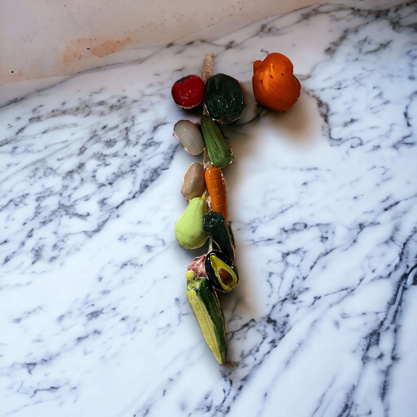 Mexican Fruit Ristra | Hand-Painted Hanging Kitchen Wall Art - hand-painted ceramic fruit ristra on marble countertop, colorful peppers, bananas, oranges
