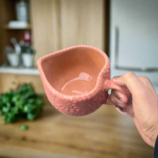 Talavera Heart Mug | Hand-Painted Pink Mexican Coffee Cup held in hand showing textured heart-shaped pink ceramic and glossy interior