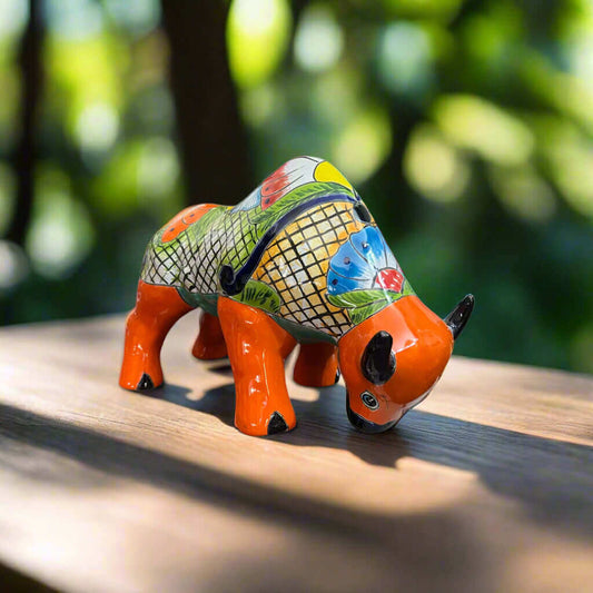 Talavera Bull Statue | Hand-Painted Mexican Ceramic Animal Decor - hand-painted orange floral Talavera bull on wooden table