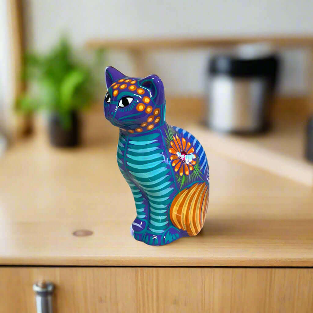 Talavera Cat Piggy Bank | Hand-Painted Mexican Ceramic Coin Holder - colorful hand-painted standing cat with floral stripes on wooden shelf