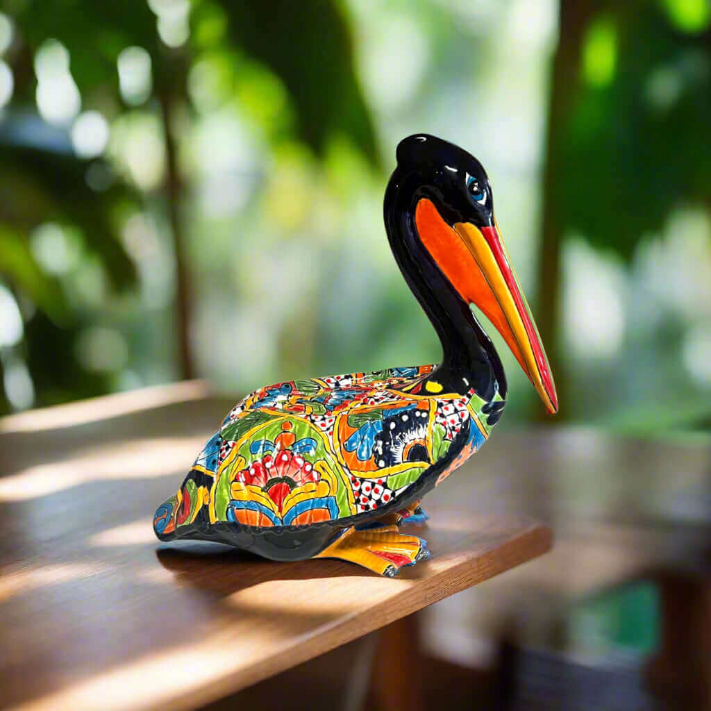 Talavera Pelican Statue | Hand-Painted Mexican Ceramic Decor - colorful hand-painted Talavera pelican on wooden table, vibrant floral and geometric designs