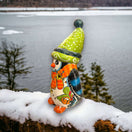 Hand-Painted Talavera Penguin Statue | Festive Christmas Decor (Medium) - hand-painted colorful Talavera penguin with green hat on snowy lakeside