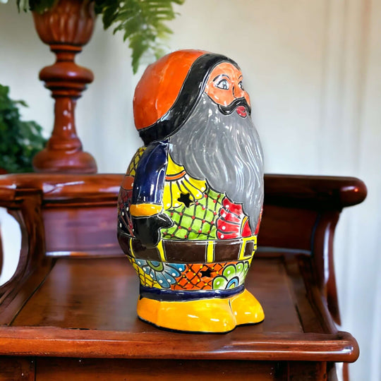 Talavera Santa Statue | Hand-Painted Holiday Decor: colorful hand-painted Talavera Santa with gray beard, red coat accents and floral motifs on wooden table