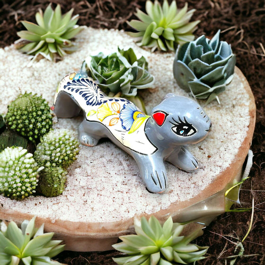 Talavera Squirrel Statue | Colorful Hand-Painted Mexican Figurine - hand-painted gray Talavera squirrel with floral motifs displayed among succulents