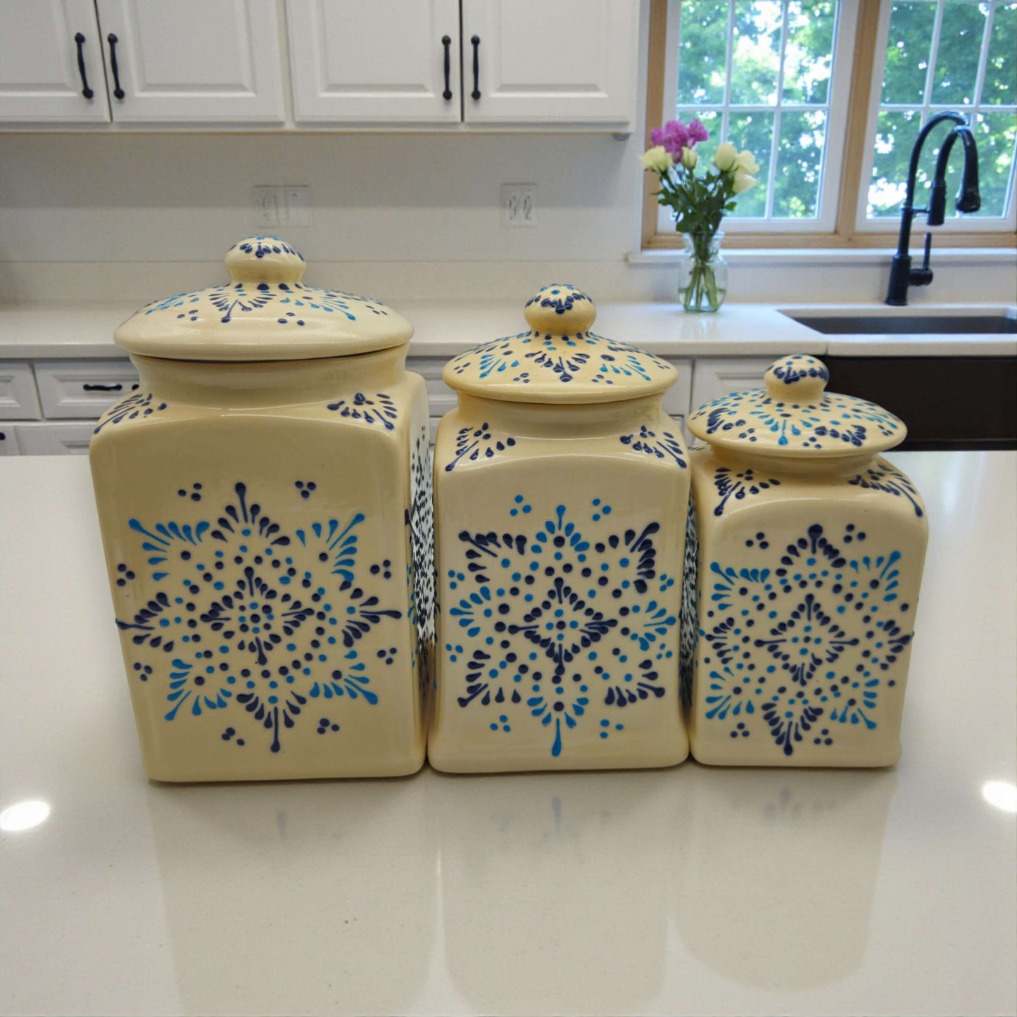 Talavera Ceramic Kitchen Canister Trio | White Multicolor Set on white countertop with blue floral Talavera patterns, handcrafted Mexican ceramic canisters