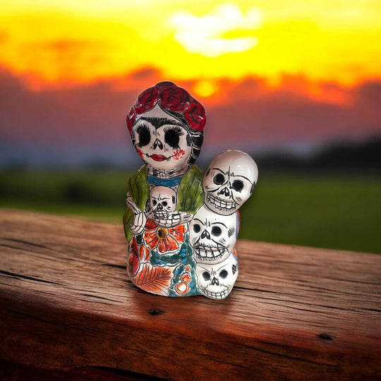 Handcrafted Talavera Frida Statue | Colorful Day of the Dead Calavera Skull Decor on wooden table with sunset background, hand-painted Talavera skull figurine