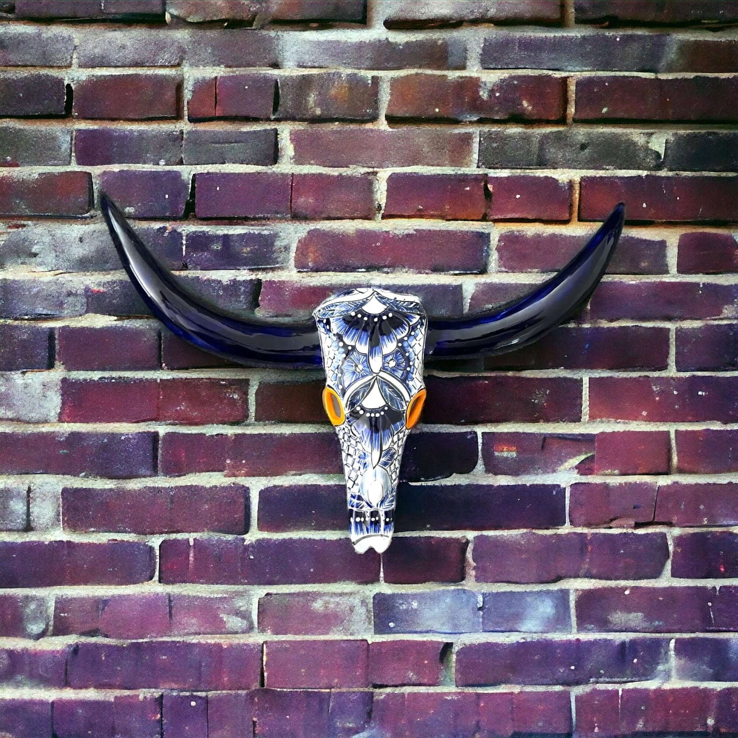 Talavera Longhorn Wall Decor | Handcrafted Mexican Bull Skull Art mounted on brick wall, hand-painted blue talavera skull with dark horns