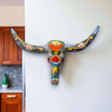 Talavera Longhorn Wall Decor | Handcrafted Mexican Bull Skull Art - hand-painted colorful Talavera skull mounted on white wall, handcrafted in Guanajuato, Mexico