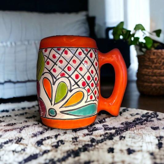 Colorful Handcrafted Mexican Coffee Mug | Talavera Ceramic Art - bright hand-painted Talavera mug with orange handle on rug