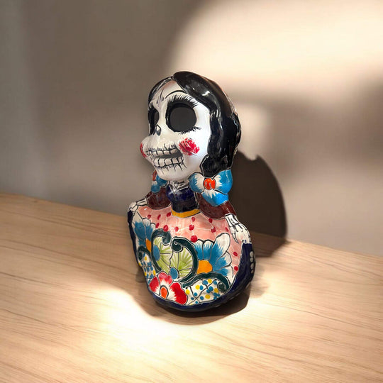 Vibrant Talavera Skeleton Woman Statue | Handcrafted Day of the Dead Decor - hand-painted Talavera skeleton woman on wooden table