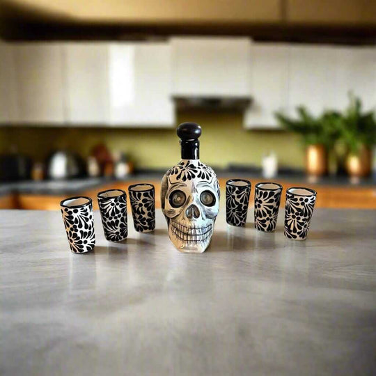 Handmade Skull Decanter Set | Black & White Mexican Barware — hand-blown skull decanter with six matching black and white shot glasses on kitchen counter