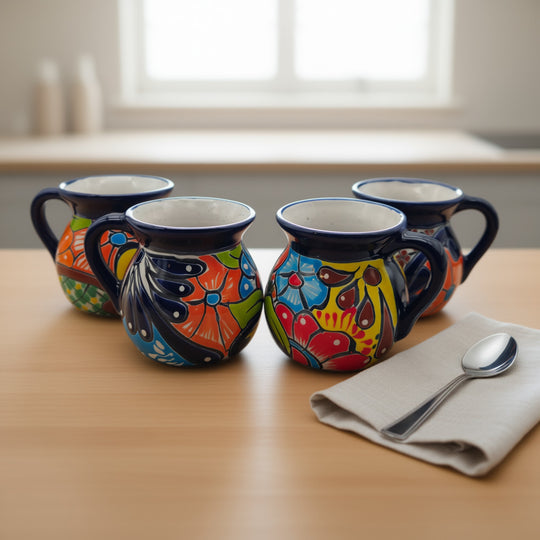 Talavera Floral Coffee Mug | Handcrafted Mexican Ceramic Cup - set of four hand-painted blue, orange, red and green floral Talavera coffee mugs on table