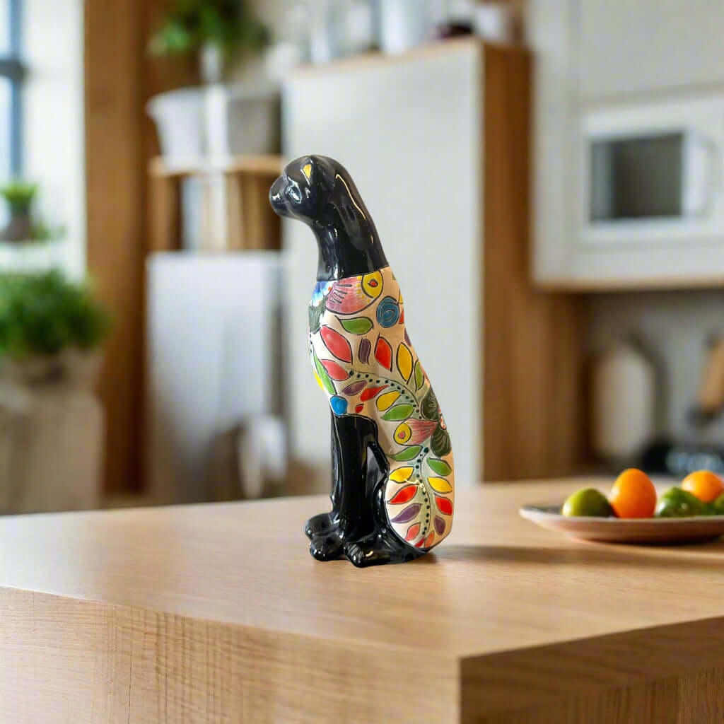 Handmade Talavera Panther Statue | Vibrant Mexican Folk Art - hand-painted black panther with colorful floral Talavera patterns on wooden kitchen counter