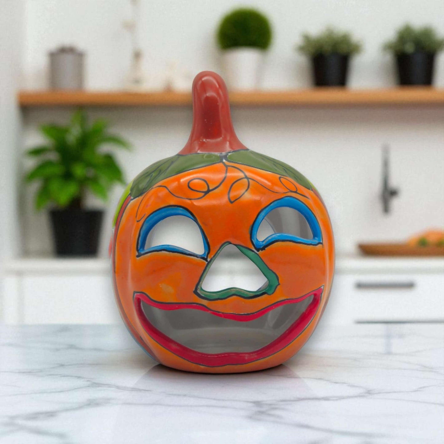 Handmade Talavera Pumpkin | Mexican Jack-O'-Lantern Decor bright orange hand-painted ceramic pumpkin with green leaves and smiling cut-out face