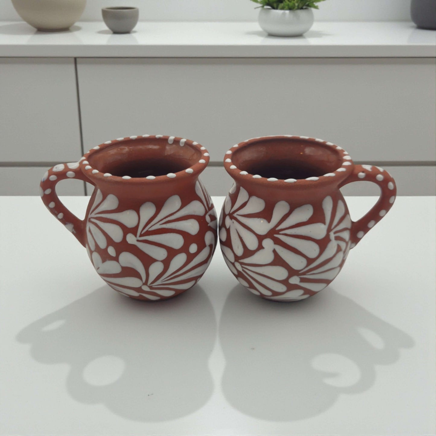 Terracotta Jarrito Mug | Handmade Mexican Relief Pottery Cup - pair of hand-painted terracotta mugs with white raised floral relief and dotted rims