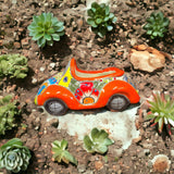 Colorful Hand-Painted Talavera Car Planter | Small Ceramic Car Statue - bright orange hand-painted Talavera succulent planter in garden soil