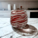 Red Swirl Stemless Wine Glass | Hand-Blown Mexican Glassware - handcrafted lead-free red and white swirled stemless wine glass on marble countertop