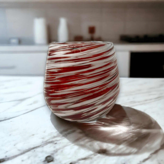 Red Swirl Stemless Wine Glass | Hand-Blown Mexican Glassware - handcrafted lead-free red and white swirled stemless wine glass on marble countertop