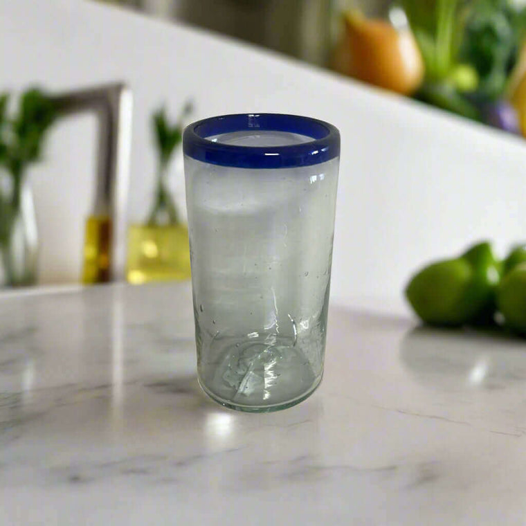 Mexican Blue Rim Tumbler | Hand-Blown Clear Glassware on marble countertop with cobalt rim and subtle bubbles