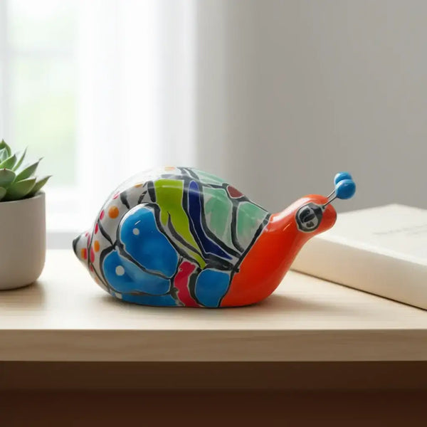 Mini Talavera Snail Figurine | Hand-Painted Mexican Ceramic - hand-painted colorful Talavera snail with floral motifs and glossy glaze on a wooden shelf