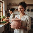 Pink Talavera Clay Bean Pot with Lid | Mexican Folk Art - woman holding hand-painted pink Talavera bean pot with lid in rustic kitchen (handcrafted, raised floral motifs)
