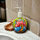 Round Talavera Soap Dispenser | Hand-Painted Ceramic Bottle on marble sink with colorful hand-painted floral motifs and clear pump