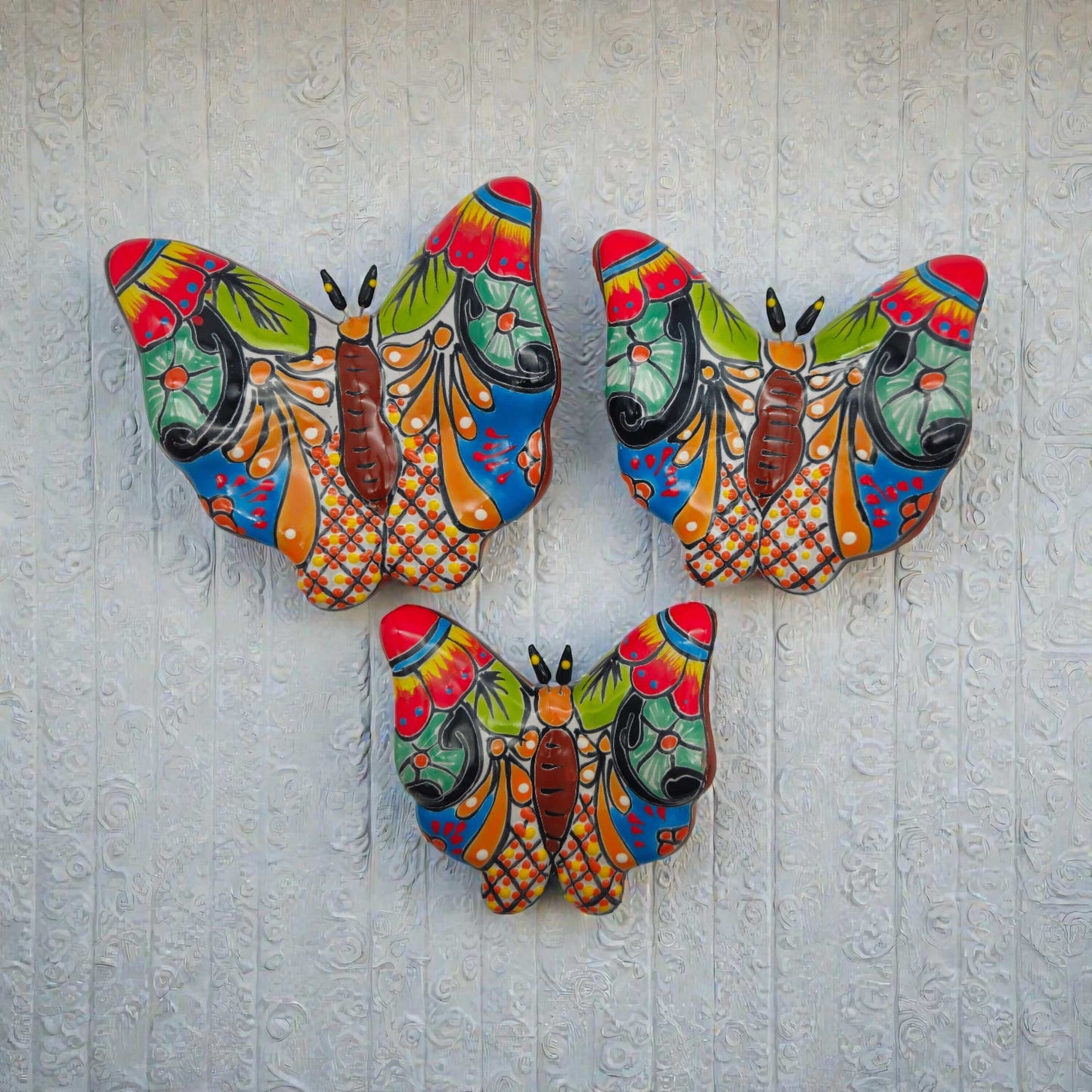 Set of 3 Talavera Butterfly Wall Art | Mexican Wall Hangings - colorful hand-painted Talavera ceramic butterflies on white textured wall