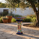 The Talavera Hub large ceramic bird bath with blue rim and colorful hand-painted Mexican folk art patterns. Stands 27" tall.