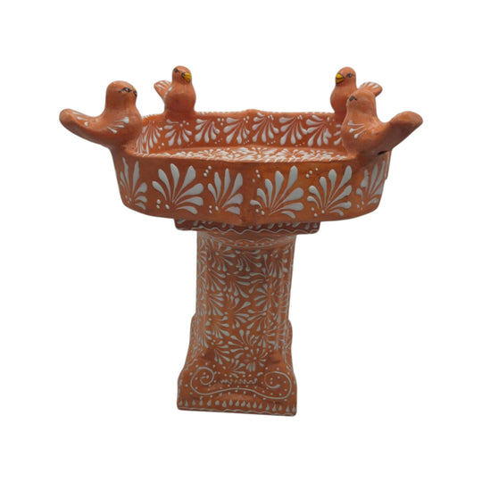 Side view of brown and white Talavera bird bath with decorated pedestal